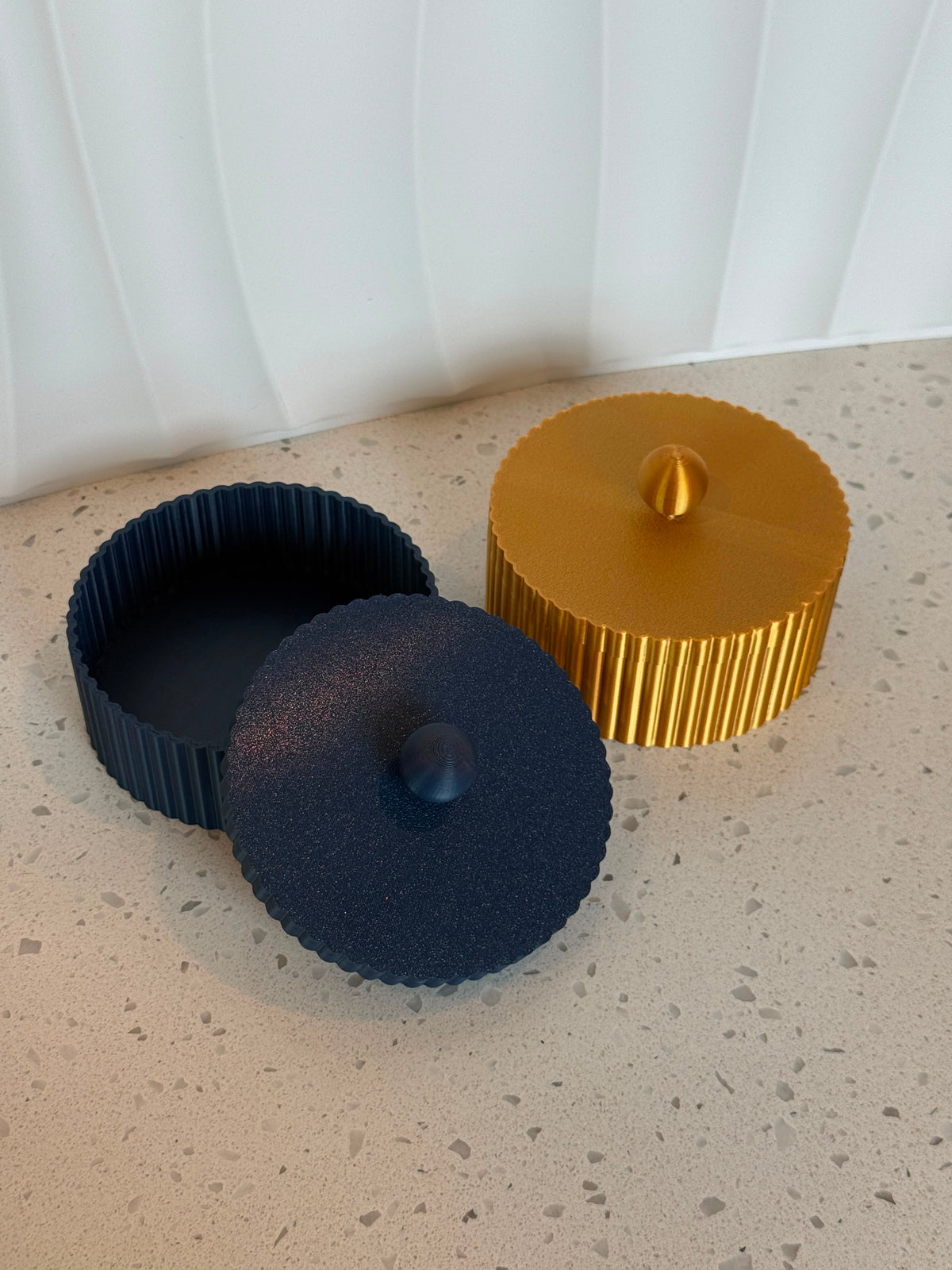 Conjunto Lumiere decorative boxes open, showing navy and gold lids