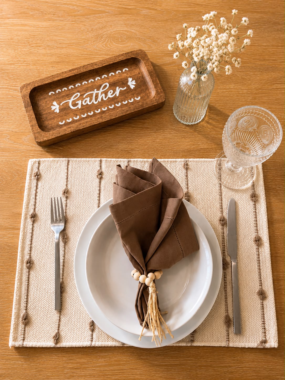 Linen and Oak table setting with brown linen napkin, wood bead napkin ring, and woven placemat